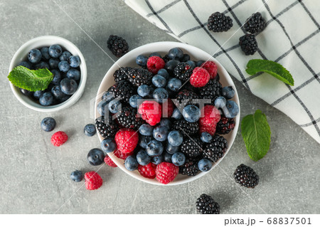 Ceramic bowls with berries on grey background, top 68837501