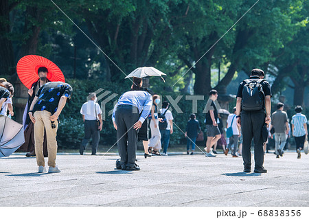 日本の東京都市景観 猛暑の中、靖国神社の大鳥居の下で深々と頭を下げる人たちら=8月15日「終戦の日」 日本の東京都市景観 猛暑の中、靖国神社の大鳥居の下で深々と頭を下げる人たちら=8月15日「終戦の日」 68838356