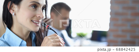 Young woman is talking on microphone in an office. 68842425