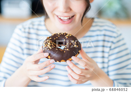 家でドーナツを食べる若い女性 68846052