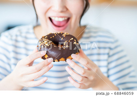家でドーナツを食べる若い女性 68846059