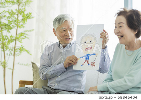 似顔絵を持って笑顔のシニア夫婦 似顔絵を持って笑顔のシニア夫婦 68846404