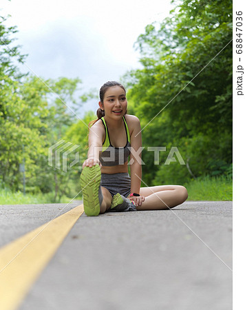 Portrait of female in sportswear stretching her Portrait of female in sportswear stretching her 68847036