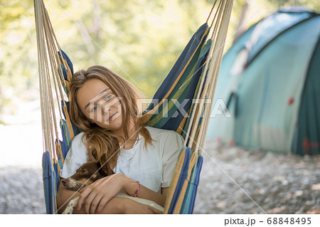 A young woman relaxing in a hammock in a wood. 68848495