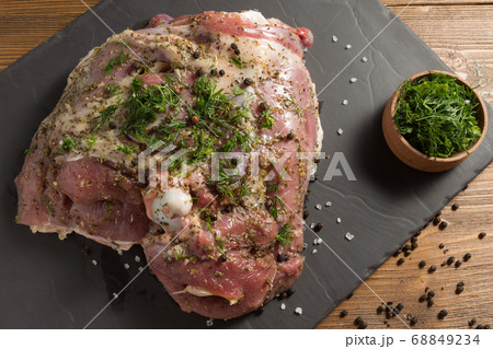 raw turkey leg with spices and herbs on a black 68849234
