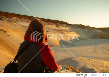 The girl in the desert sits on a stone 68850244