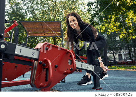 Photo of young european woman on a street workout in sports park on sunny day. Concept of training outdoor. Photo of young european woman on a street workout in sports park on sunny day. Concept of training outdoor. 68850425