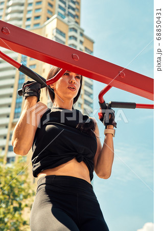 Photo of young european woman on a street workout in sports park on sunny day. Concept of training outdoor. Photo of young european woman on a street workout in sports park on sunny day. Concept of training outdoor. 68850431