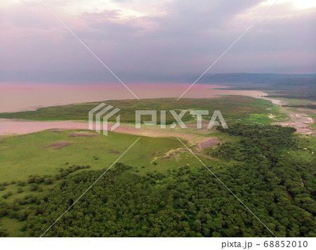 Aerial Drone view of Lake Manyara National Park with Pink Lake and Lush Primal Rain Forest in a Cloudy Weather 68852010