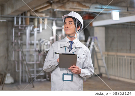 ヘルメットをしてタブレットを見ながら現場を確認する監督 ヘルメットをしてタブレットを見ながら現場を確認する監督 68852124
