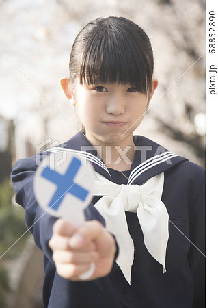 バツのプレートを持つ女子中学生 68852890