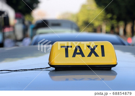 Taxi light sign or cab sign in yellow color with black text on the car roof 68854879