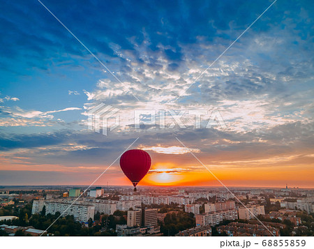 Red hot air balloon flying over small european 68855859