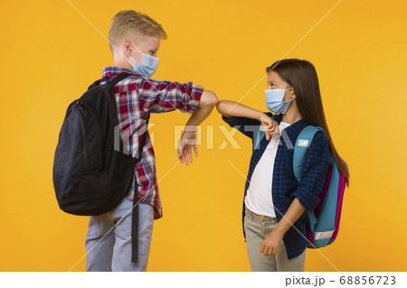 Two students standing together, bumping elbows at studio 68856723