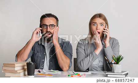 Frightened and shocked man with beard and glasses and with open mouths in workplace Frightened and shocked man with beard and glasses and with open mouths in workplace 68857247