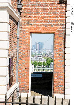 ロンドングリニッチ天文台の赤煉瓦の建物から見えるロンドンの近代的な高層ビル 68857258