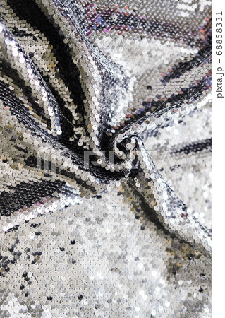 Sequin fabric texture. Shiny silver sparkling background. Clothing piece of glitter metallic for a glamorous party, celebration. Close-up. Sequin fabric texture. Shiny silver sparkling background. Clothing piece of glitter metallic for a glamorous party, celebration. Close-up. 68858331