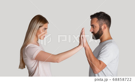 Resist domestic tyrant. Concentrated woman pushes male hands with hands, staring at each other menacingly 68858722