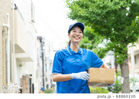 荷物を届ける宅配便の若い女性ドライバー 荷物を届ける宅配便の若い女性ドライバー 68860330