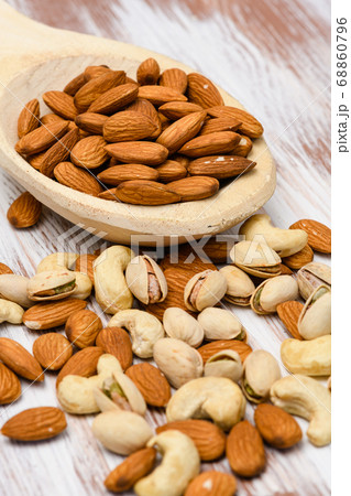 Almonds in a wooden spoon on a wooden background. 68860796
