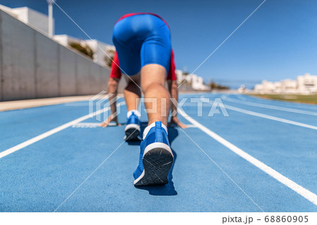 Sprinter at starting line waiting to start run race competition at track and field outside stadium. Athlete runner man running outdoors 68860905
