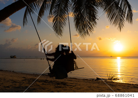 Silhouetted couple in love walks on the beach Silhouetted couple in love walks on the beach 68861041