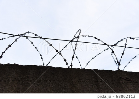 Fence with barbed wire against a blue sky background 68862112