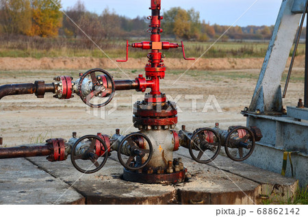 Industrial piping with steel flanges and bolts on oil field. Fuel pipes valves and crude pipelines 68862142