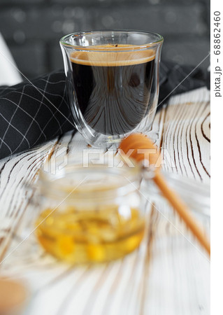 Glass cup of coffee on wooden kitchen table 68862460