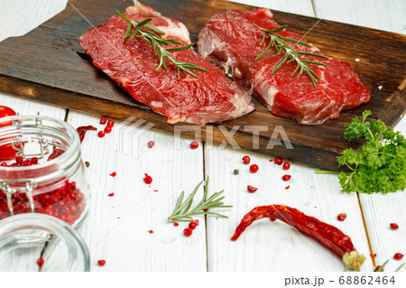 Barbecue veal steaks with rosemary on wooden board Barbecue veal steaks with rosemary on wooden board 68862464