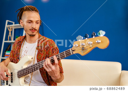 Young caucasian man with dreadlocks playing electric guitar in his room 68862489
