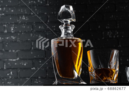 Whisky glass against dark black grunge wall 68862677