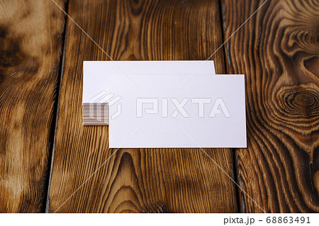 Stack of white business cards on brown wooden background Stack of white business cards on brown wooden background 68863491