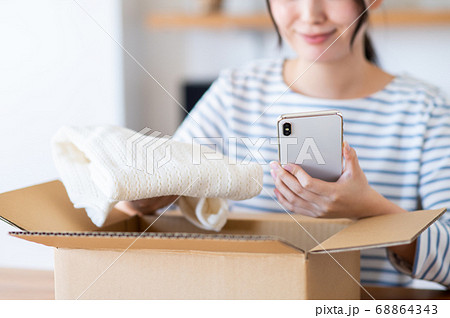 スマホで衣料品を見る若い女性 68864343