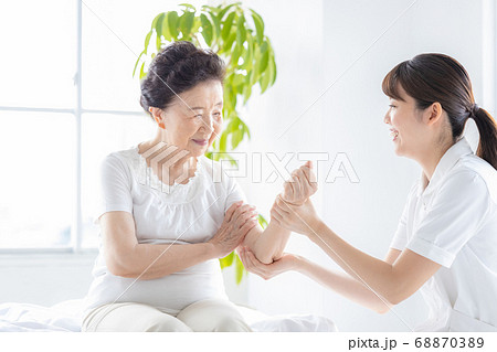 医療　腕のリハビリをするシニア女性と理学療法士 68870389