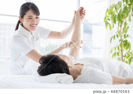 医療　理学療法士と体操をするシニア女性 68870563