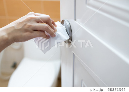 Girl open the door of a public toilet,hand of woman using tissue paper to touch the door knob instead of hands to prevent infection of Covid-19,pandemic of Coronavirus,outbreak of contagious diseases 68871345