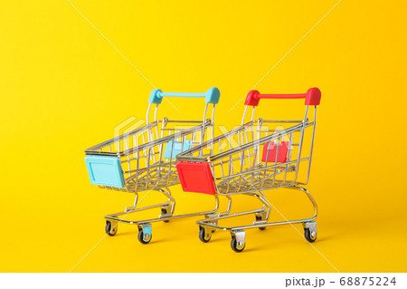 Small shopping carts on yellow background, space Small shopping carts on yellow background, space 68875224