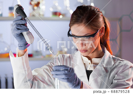 Young scientist pipetting in life science laboratory. Young scientist pipetting in life science laboratory. 68879528