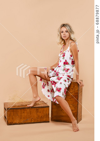 Woman in long sundress sits on apple box over 68879877