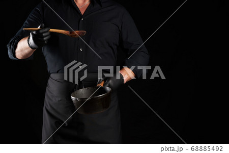 cook in black uniform and latex gloves holds an 68885492