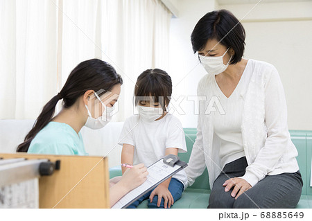 病院で診察する前に問診を受ける女の子の写真素材