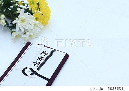 菊と一緒に置かれた香典袋 68886314