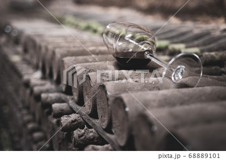glass with red wine on aged wine bottles in glass with red wine on aged wine bottles in 68889101