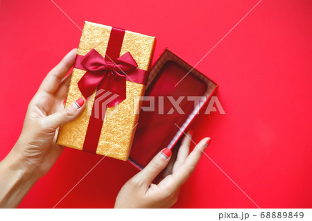 female hands with beautiful manicure open a gift 68889849