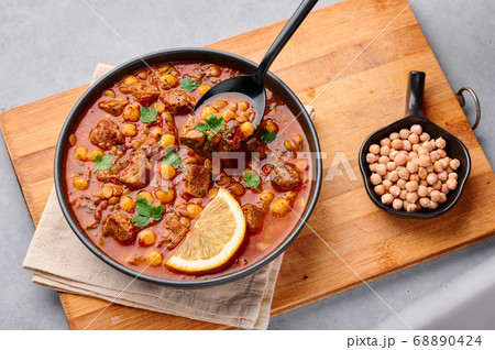 Moroccan Harira Soup in black bowl at grey table top Moroccan Harira Soup in black bowl at grey table top 68890424