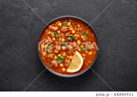 Moroccan Harira Soup in black bowl at dark slate table top Moroccan Harira Soup in black bowl at dark slate table top 68890431