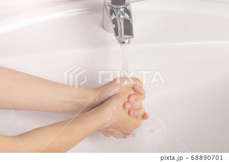 Teenager washes her hands with soap in the sink in the bathroom. Personal care concept 68890701