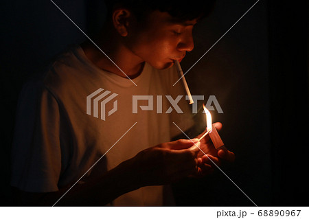マッチでタバコに火をつける男性の写真素材 マッチでタバコに火をつける男性の写真素材