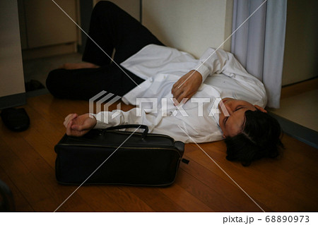 飲みすぎて玄関で寝る男性 68890973